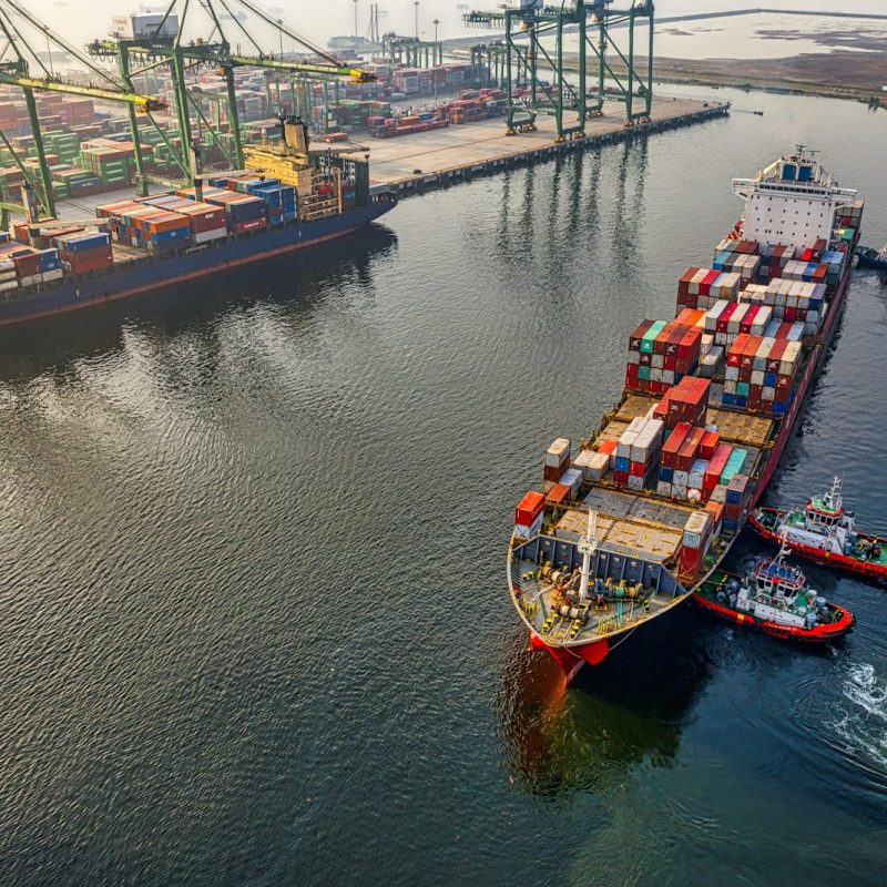 red and blue cargo ship on body of water during daytime